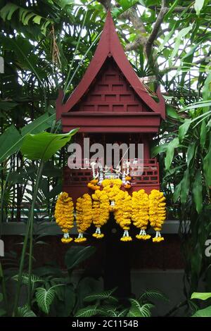 Bangkok, Thaïlande - 9 avril 2014 : les Garlands décorent une petite pagode ou une maison d'esprit utilisée pour la prière bouddhiste au musée Jim Thompson House Banque D'Images