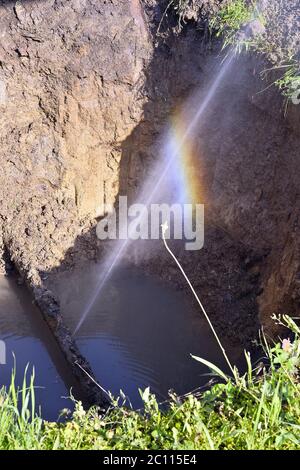 Le jet d'eau sous forme de fuite dans le tuyau métallique endommagé sur le site de production Banque D'Images