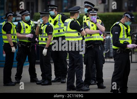 La police patrouille alors que des activistes se rassemblent au cenotaphe de George Square, à Glasgow, pour le protéger contre toute attaque de vandalisme après que la Ligue de défense loyaliste ait demandé aux partisans de se réunir pour un événement « Protect the Cenotaph » en réponse aux statues en cours de déposition en Écosse à la suite des manifestations Black Lives Matter. Banque D'Images