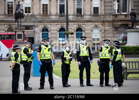 La police patrouille alors que des activistes se rassemblent au cenotaphe de George Square, à Glasgow, pour le protéger contre toute attaque de vandalisme après que la Ligue de défense loyaliste ait demandé aux partisans de se réunir pour un événement « Protect the Cenotaph » en réponse aux statues en cours de déposition en Écosse à la suite des manifestations Black Lives Matter. Banque D'Images