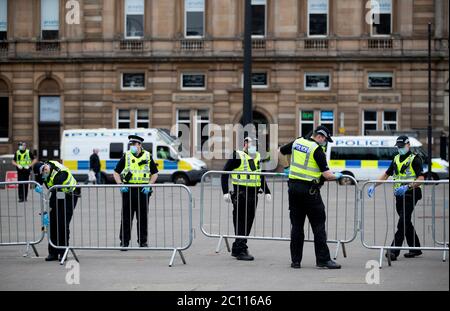 La police a mis en place des barricades alors que des activistes se rassemblaient au cénotaphe de George Square, à Glasgow, pour le protéger contre toute attaque de vandalisme après que la Ligue de défense loyaliste ait demandé aux partisans de se réunir pour un événement « Protect the Cenotaph » en réponse à des statues en cours de dédressées en Écosse à la suite des manifestations Black Lives Matter. Banque D'Images