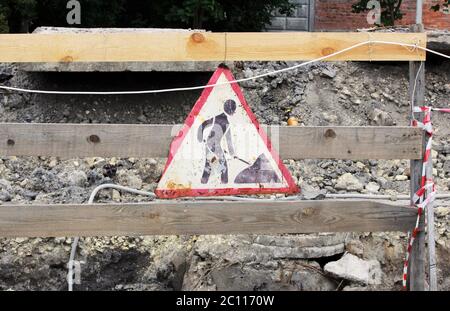 travaux de réparation de panneaux anciens suspendus sur une clôture en bois tout en éliminant les accidents de conduites d'eau. Banque D'Images