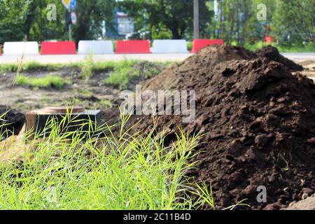 ruissellement des eaux pluviales, trappe et pelouse, clôturé avec des protections en plastique sur place construction de routes. Banque D'Images