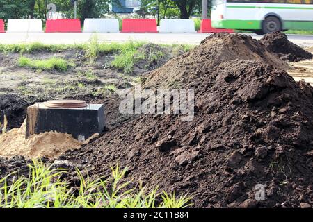 ruissellement des eaux pluviales, trappe et pelouse, clôturé avec des protections en plastique sur place construction de routes. Banque D'Images