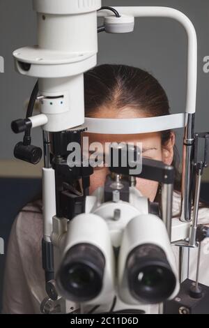 Belle jeune femme ayant l'essai d'oeil à l'optométriste Banque D'Images