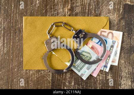 Enveloppe avec billets d'euro et menottes Banque D'Images