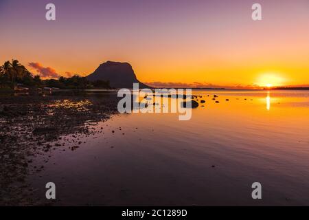 Bateaux de pêche dans un océan calme au coucher du soleil. Le Morn montagne en arrière-plan à l'île Maurice. Banque D'Images