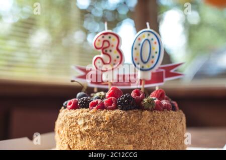 Blackberry framboises gâteau d'anniversaire avec des bougies numéro 30 Banque D'Images