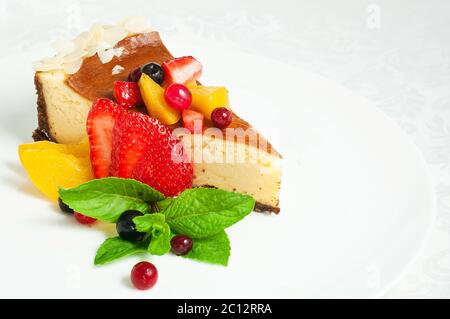 Service de cheesecake dans une assiette de fruits Banque D'Images