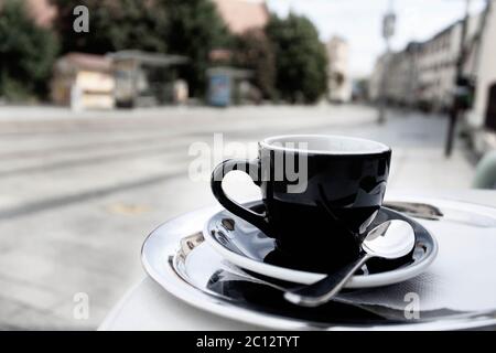 Une tasse d'espresso fraîchement préparé servi dans une rue principale du centre-ville de Bratislava. Image désaturée. Banque D'Images