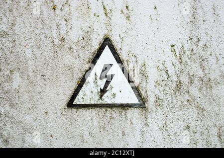 L'ancien panneau haute tension sur la plaque de métal blanc Banque D'Images