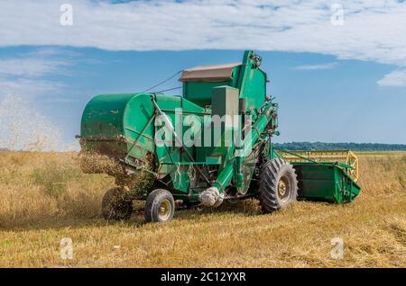 Vieux grain harvester travaillent encore dans le domaine Banque D'Images