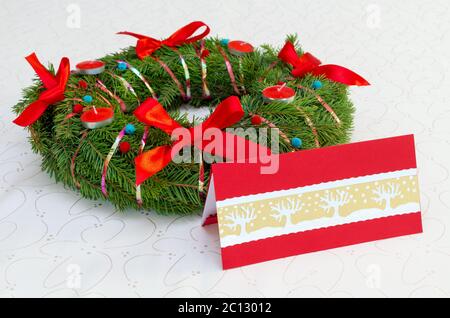 Couronne de Noël classique avec bougies rouges et carte sur la nappe Banque D'Images