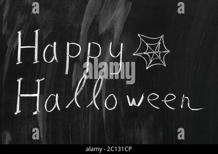 Happy Halloween writed avec craie blanche sur un tableau noir. Banque D'Images