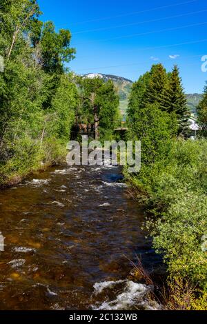 Le ruissellement printanier remplit le ruisseau avec la station de ski de Steamboat Springs en arrière-plan Banque D'Images