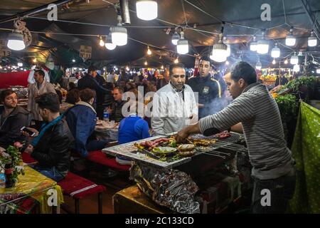 La rue en plein air propose des vendeurs cuisinant et servant de la nourriture sur la place principale de la place Jemaa El Fna à Marrakech Maroc la nuit Banque D'Images
