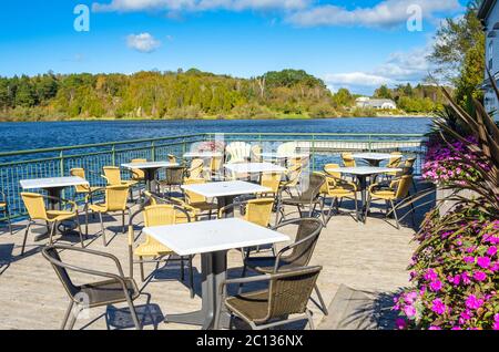 Terrasse au bord du lac vide avec tables et chaises par une journée d'automne claire Banque D'Images