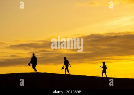 Gran Canaria, Îles Canaries, Espagne. 13 juin 2020. Les habitants de la région se retrouvent sur la vaste étendue de dunes de sable de Maspalomas sur la Grande Canarie au coucher du soleil. Avant Covid les dunes seraient également pleines de touristes regardant le coucher du soleil. Les îles Canaries et de nombreuses autres régions d'Espagne, sont dans la phase finale d'un verrouillage quatre phases du coronavirus de désescalade. L'économie des îles Canaries étant fortement tributaire du tourisme, les habitants sont impatients de voir le retour des touristes. Crédit : Alan Dawson/Alay Live News Banque D'Images