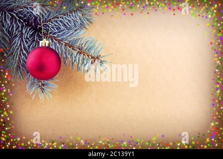 Boule de Noël rouge sur branche d'épinette verte et cadre brillant. Banque D'Images