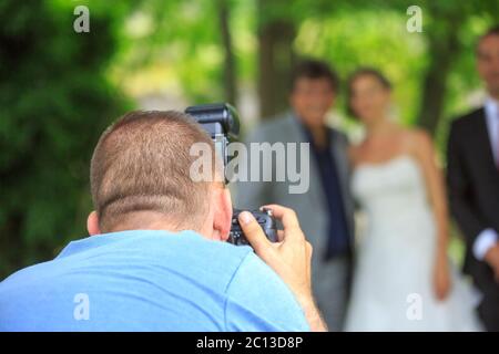 Photographe de mariage en action, prenant une photo de la mariée et marié Banque D'Images