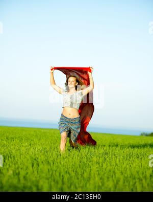 Jeune femme heureuse en champ de blé avec le tissu. Vie d'été Banque D'Images