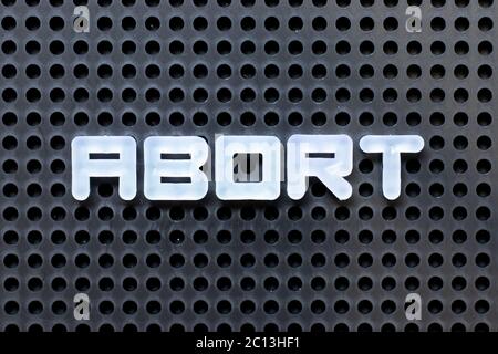 Alphabet blanc avec mot abandon sur fond noir de fond perforé Banque D'Images