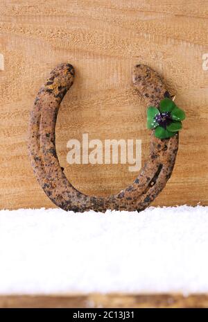Trèfle à quatre feuilles en fer à cheval sur bois. Banque D'Images