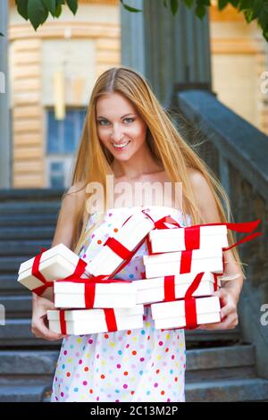 Boîtes-cadeaux dans les mains de la jeune femme blonde Banque D'Images