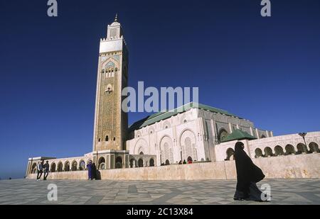 07.11.2010, Casablanca, Maroc, Afrique - UNE femme voilée passe devant la mosquée Hassan II, la deuxième plus grande mosquée d'Afrique. Banque D'Images