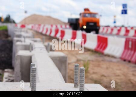 construction de la jonction de route au viaduc avec des barrières en béton et des arrêts en plastique blanc rouge près de la . Banque D'Images