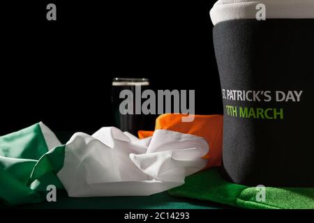 St Patrick day avec une pinte de bière noire, chapeau et drapeau irlandais sur une table verte Banque D'Images