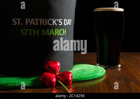 Libre de St Patrick day avec une pinte de bière noire, chapeau et shamrock sur une table Banque D'Images