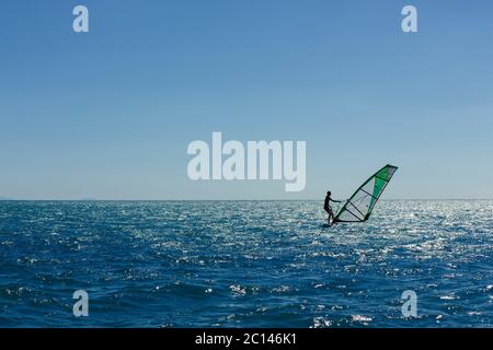 silhouette panoramique de planche à voile contre une mer bleue pémante Banque D'Images