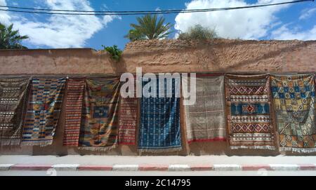 Tapis à vendre accrochés sur un mur le long de la route près de Fès au Maroc Banque D'Images