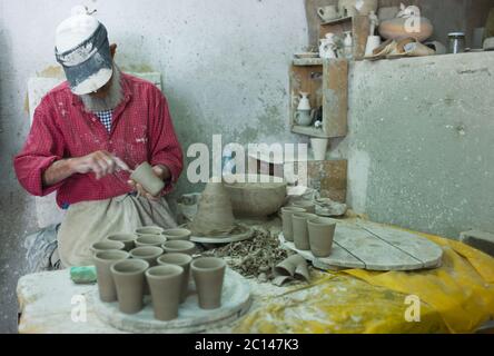 Un homme marocain forme des tasses en argile dans une usine de poterie à Fès, au Maroc. Banque D'Images