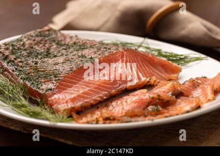 saumon fumé séché gravlax avec aneth sur un plateau blanc et serviette en arrière-plan Banque D'Images