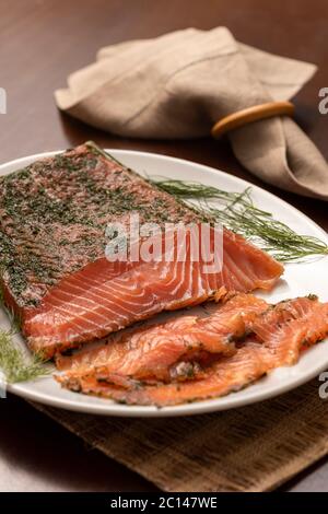 saumon fumé séché gravlax avec aneth sur un plateau blanc et serviette en arrière-plan Banque D'Images