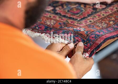 couture traditionnelle à la main fixant vieux vieux vieux tapis persan antique de près Banque D'Images