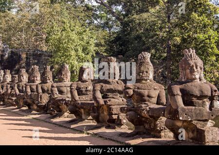 Asuras, ou devils, tirant le serpent Naga à travers l'entrée de la porte est à Angkor Thom, Cambodge. Les statues font partie d'une représentation du Chur Banque D'Images