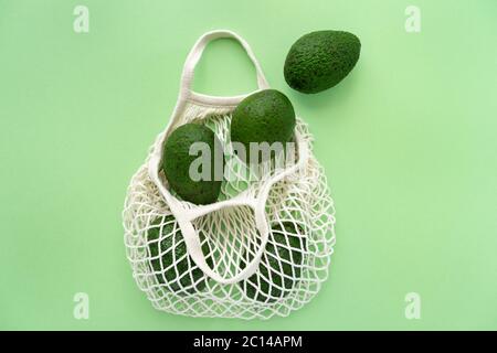 Sac de coton en maille éco d'épicerie avec avocats.Vegetarisme. Concept de shopping et de mode de vie écologique. Banque D'Images