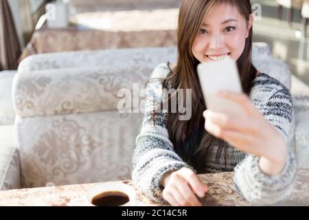 une jeune femme est assise dans un café Banque D'Images