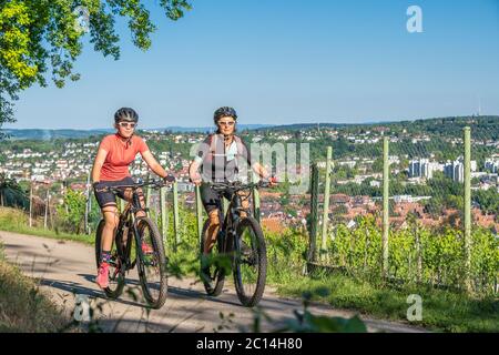 Grand-mère et petite-fille à vélo tout terrain et s'amuser dans un après-midi ensoleillé dans les vignobles au-dessus de la ville de Stuttgart, Banque D'Images