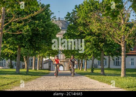 Grand-mère et petite-fille à vélo tout terrain et s'amuser un après-midi ensoleillé devant le château de Soliude, près de la ville de Stuttgart Banque D'Images