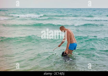 un homme avec un chien nageant dans la mer Banque D'Images