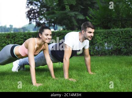 Jeune couple l'exercice et les étirements muscles avant l'activité sportive Banque D'Images