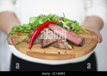 Filet de bœuf moyen rare grillé Ribeye dans les mains d'une femme Banque D'Images