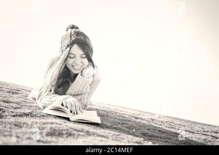 Une jeune femme de 25 ans s'apprécie tout en lisant un livre seul dans le parc Banque D'Images