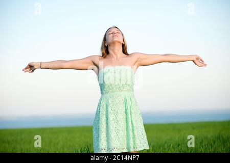 Bonheur femme rester extérieur sous la lumière du soleil de coucher du soleil Banque D'Images