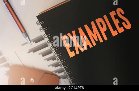 Exemples mot écrit sur un copybook couverture orange sur noir. Concept d'entreprise et d'éducation. Mise au point sélective Banque D'Images