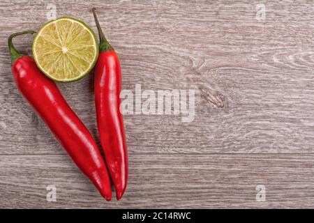 Piment et citron vert sur fond de bois Banque D'Images
